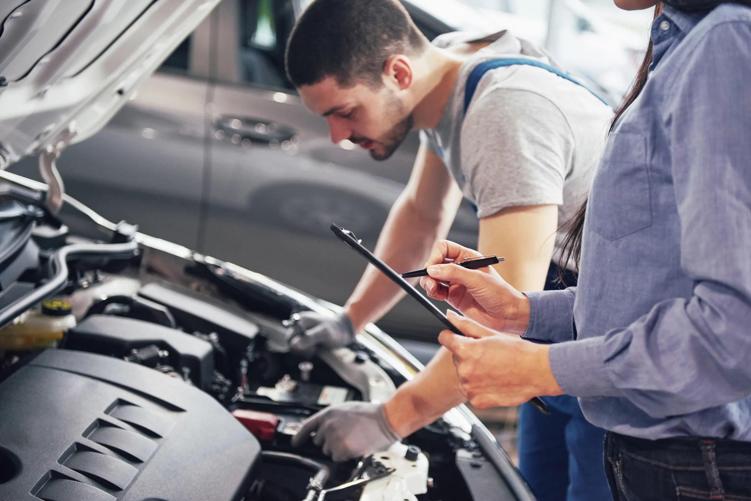 Technician carrying out vehicle diagnostic inspection before module replacement
